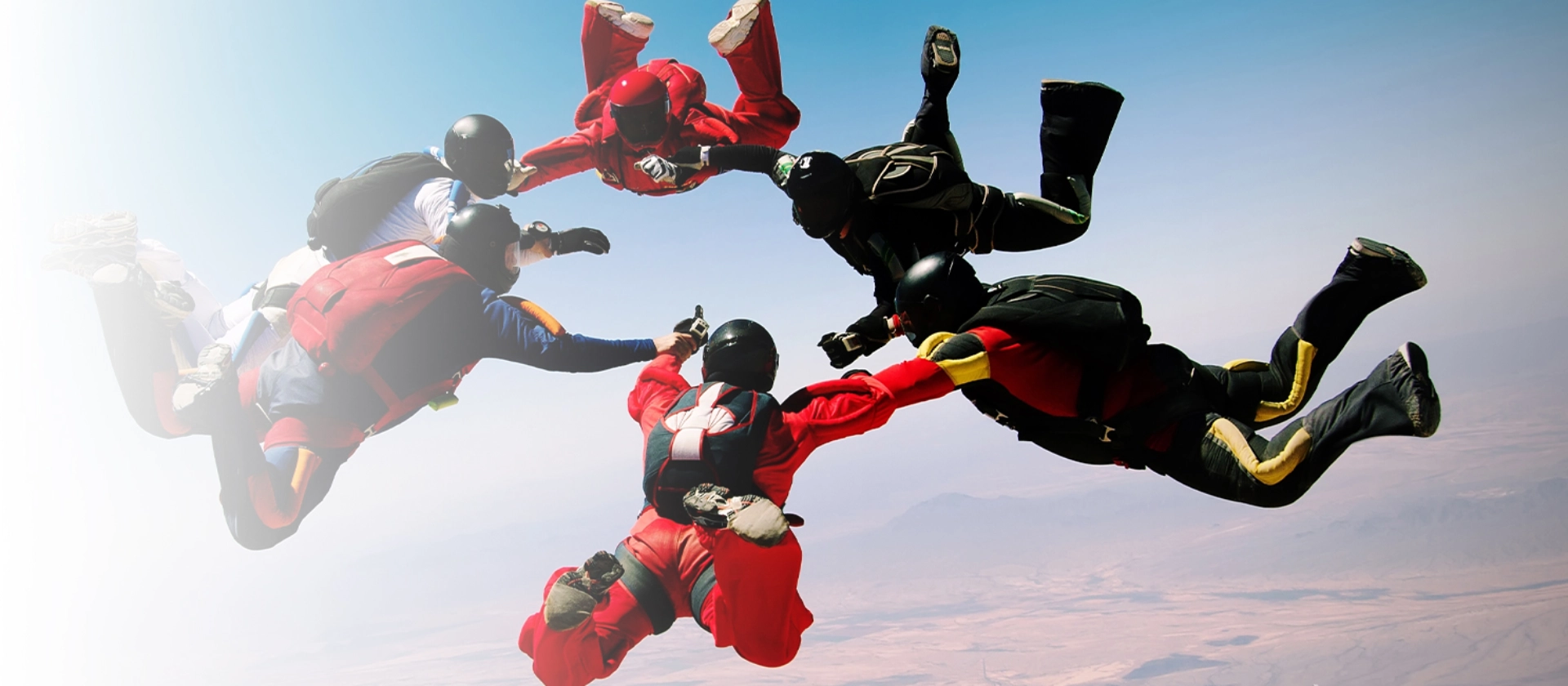 Mehrere Fallschirmspringer während ihres Sprungs symbolisieren den Mut von msg advisors