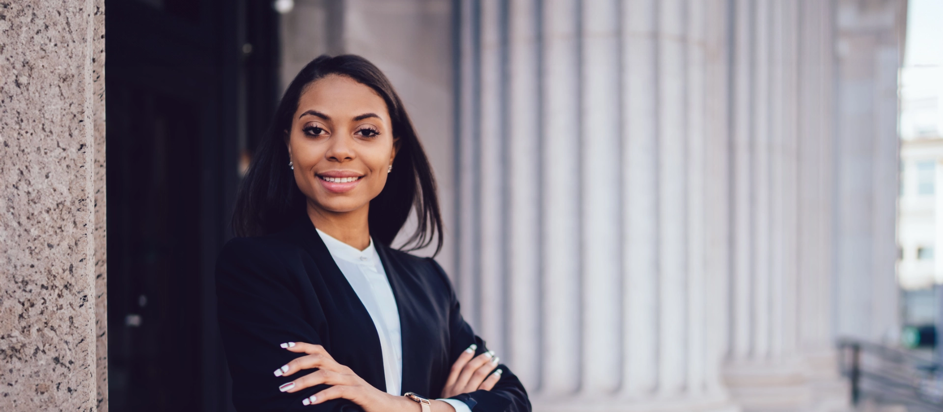 Frau in Businessanzug vor Säuleneingang