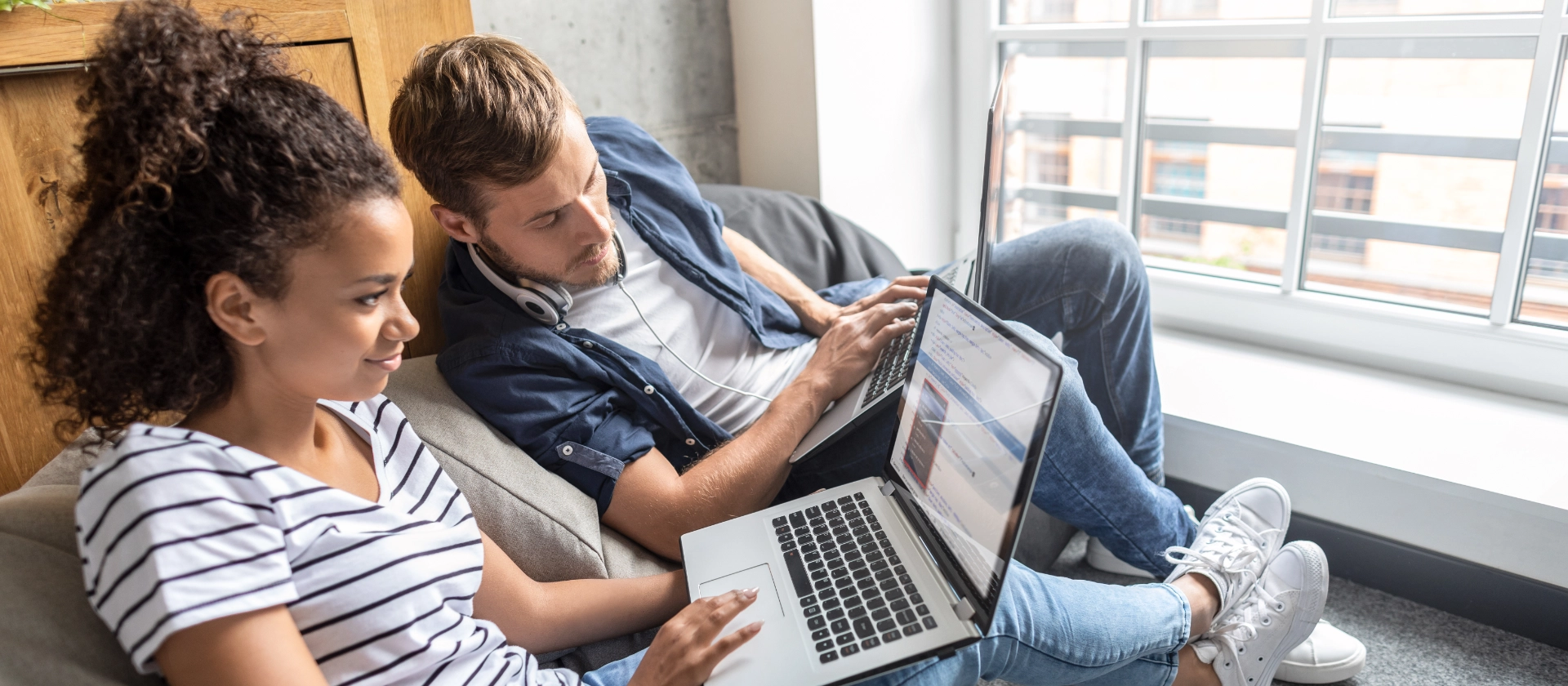 Ein Ausbilder zeigt einer IT-Auszubildenden etwas auf deren Laptop