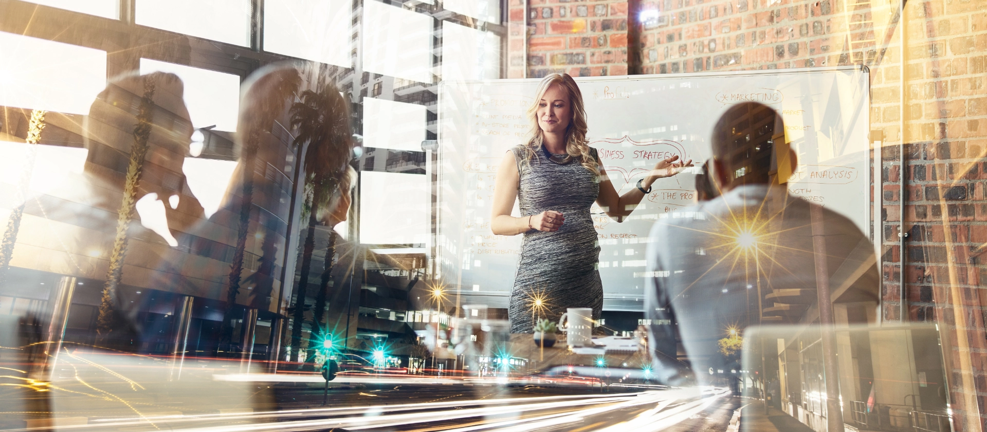 Eine Frau zeigt ihren Kolleginnen und Kollegen in der Branche Automotive etwas an einem Whiteboard