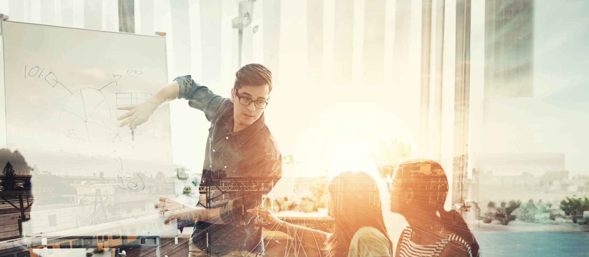 Ein Mitarbeiter aus dem Bereich Travel and Logistics präsentiert seinen Kolleginnen und Kollegen etwas an einem Whiteboard