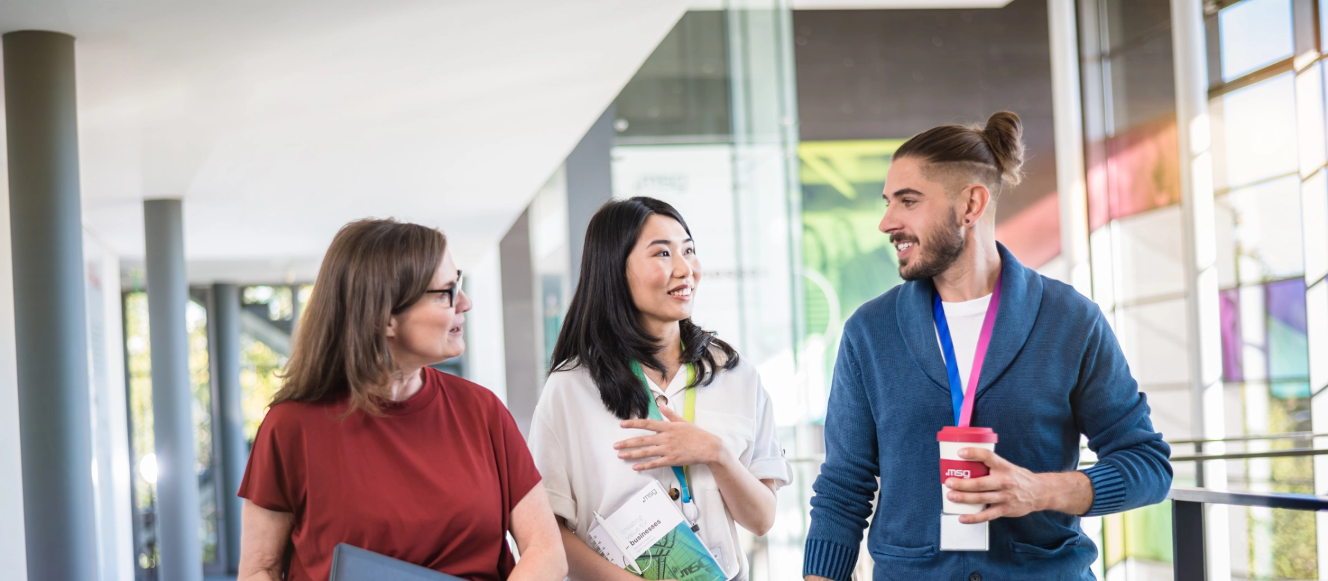Eine gemischte Gruppe von msg-Mitarbeitenden in einem hellen Korridor am msg-Standort Ismaning